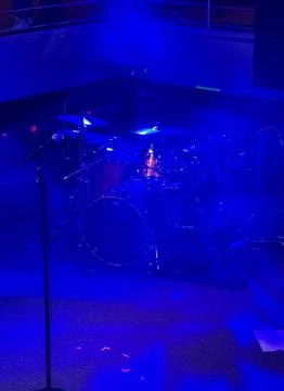 Drum kit illuminated by blue stage lights Stock Photos