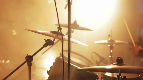 Drum set with cymbals against background of playing drummer and yellow light on Stock Footage 311646779