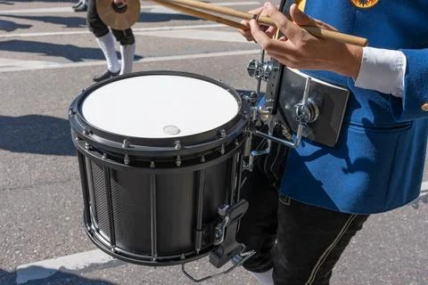 A drummer beats a drum marching down the street, close-up photo. Stock Photos