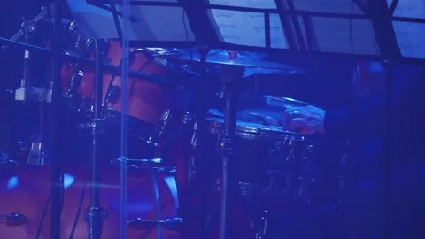 Drummer in a black suit playing a drum cymbal at a concert. Blue stage lighting Stock Footage 259933499