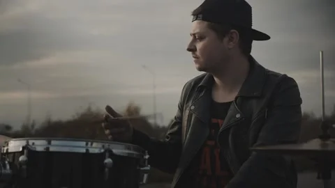 Drummer in a bunny jacket twists a drumstick Vidéo 131734308