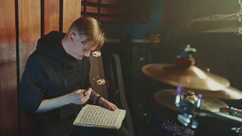 Drummer composing music at a studio workspace during an evening session 스톡 동영상 305846678