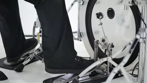 Drummer dressed in black playing white drumset, white floor, legs only Stock Footage 142192541
