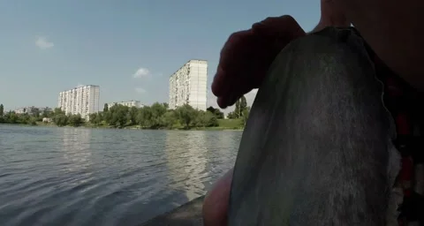 Drummer hands playing on a makeshift drum on a background of lake and building Stock Footage 50454712