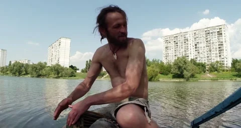 Drummer hands playing on a makeshift drum on a background of lake and building Stock Footage 50454740