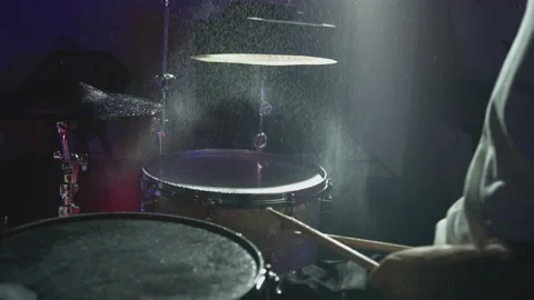 The drummer hits the wet drum cymbal with his drumstick and the water splashes Stock Footage 163085232