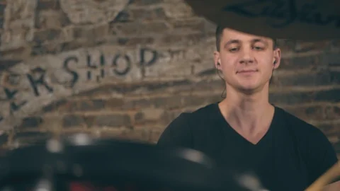 Drummer man plays drums on background of brick wall in garage Stock Footage 103416087