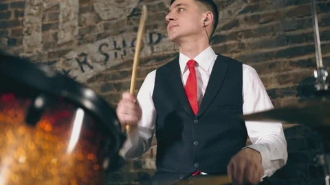 Drummer man plays drums on background of brick wall in garage Stock Footage 105164113