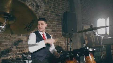 Drummer man plays drums on background of brick wall in garage Stock Footage 105164320