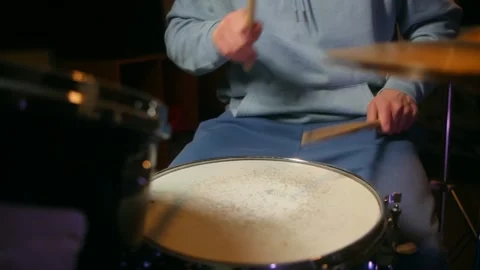 Drummer passionately plays drum set with dynamic stick movements, showcasing Stock Footage 312845447