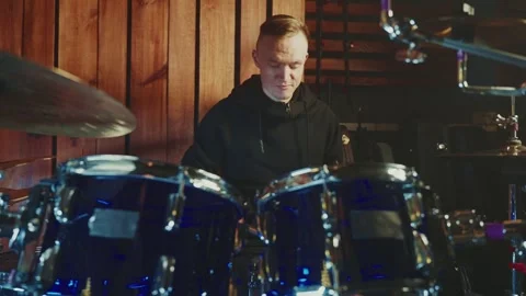Drummer performs energetic beats in a cozy studio setting Stock Footage 295331488