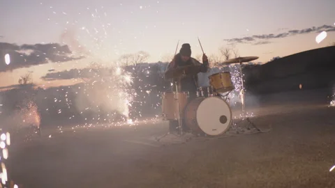 Drummer performs with fireworks during sunset in outdoor celebration Stock Footage 320018747