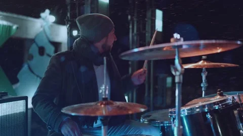 The drummer performs outside in winter in snowy weather at night Stock Footage 167338791