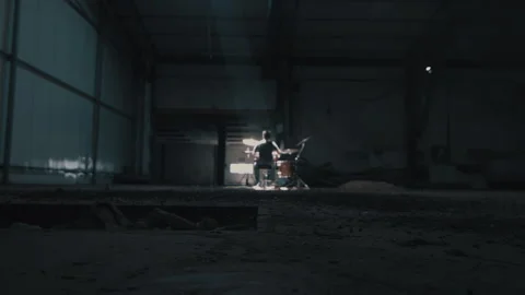 Drummer playing on a drum kit in dark warehouse Stock Footage 275101746