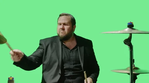 Drummer playing on drum-set in studio against green background Stock Footage 248640989