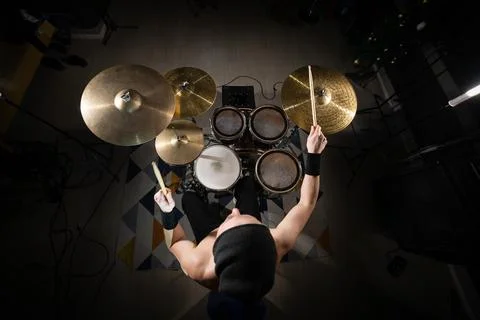 Drummer playing electronic drum kit performing music Stock Photos