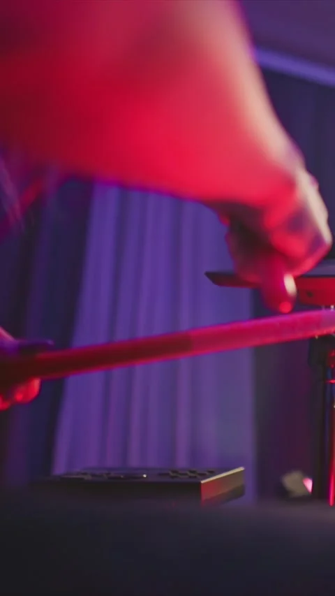 Drummer playing red drums in dim purple lit environment with rhythmic hand and Stock Footage 346795496