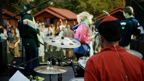 A drummer plays on the background of dancing people. Stock Footage 120193016