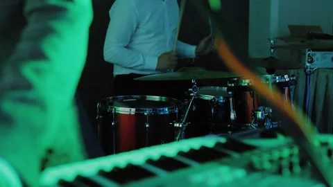 Drummer plays on drums, focus transition to keyboard player's hands play keys Stock Footage 137706678