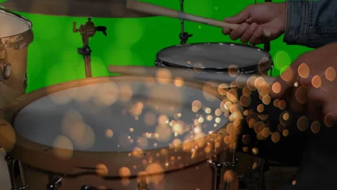 Drummer positioning sticks on tom, tapping beats, creating golden bokeh over Video stock 313703670