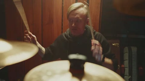 Drummer practices intense rhythm in dimly lit studio during late night session Видео 295331554