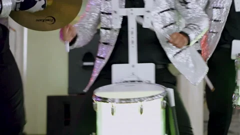 A drummer in a silver jacket plays a drum with LED lights in different colors. Stock-Footage 149545153