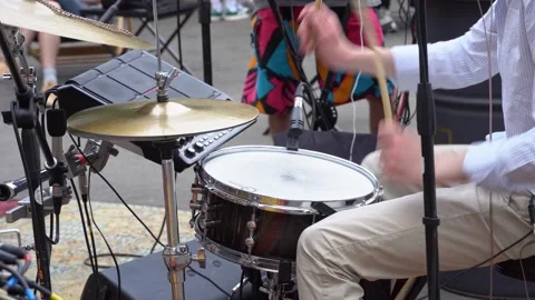 Drummer taps drumsticks on a drum kit at a street music festival. Cover band Stock Footage 244810678