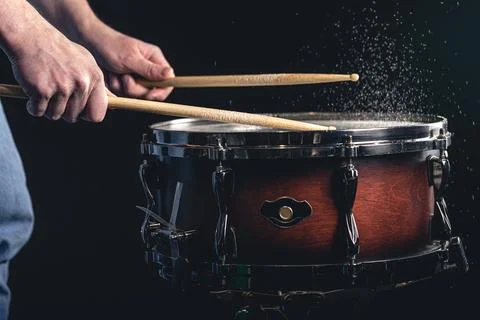 Drummer using drum sticks hitting snare drum with splashing water. Stock Photos