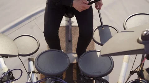 The drummer's hands play on an electronic drum kit, close-up shooting on sunset Stock Footage 243639580