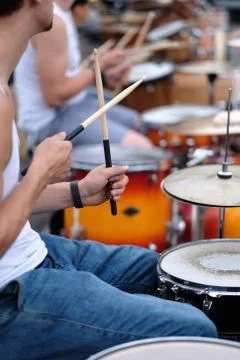 The drummer's hands with a stick behind the drum set. Foto stock