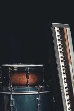 Drums and keys on a black background, the concept of musical creativity. Stock Photos