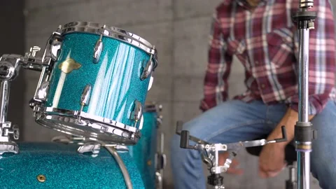 Drums on the background male is Setting Up A Drum Set / Lesson. Stock Footage 155554922