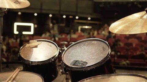 Drums on stage, audience comes to the show, red seats in background Stock Footage 76368566
