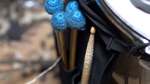 Drumsticks with soft blue tips are tucked into a black bag next to the drum 스톡 동영상 107193211