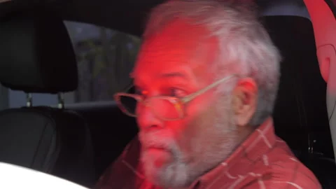 Drunk aged man with beard and glasses sits in automobile Stock Footage 154997436