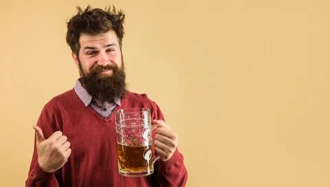 Drunk bearded man with large mug of beer showing thumb up. Craft beer in re.. Foto stock