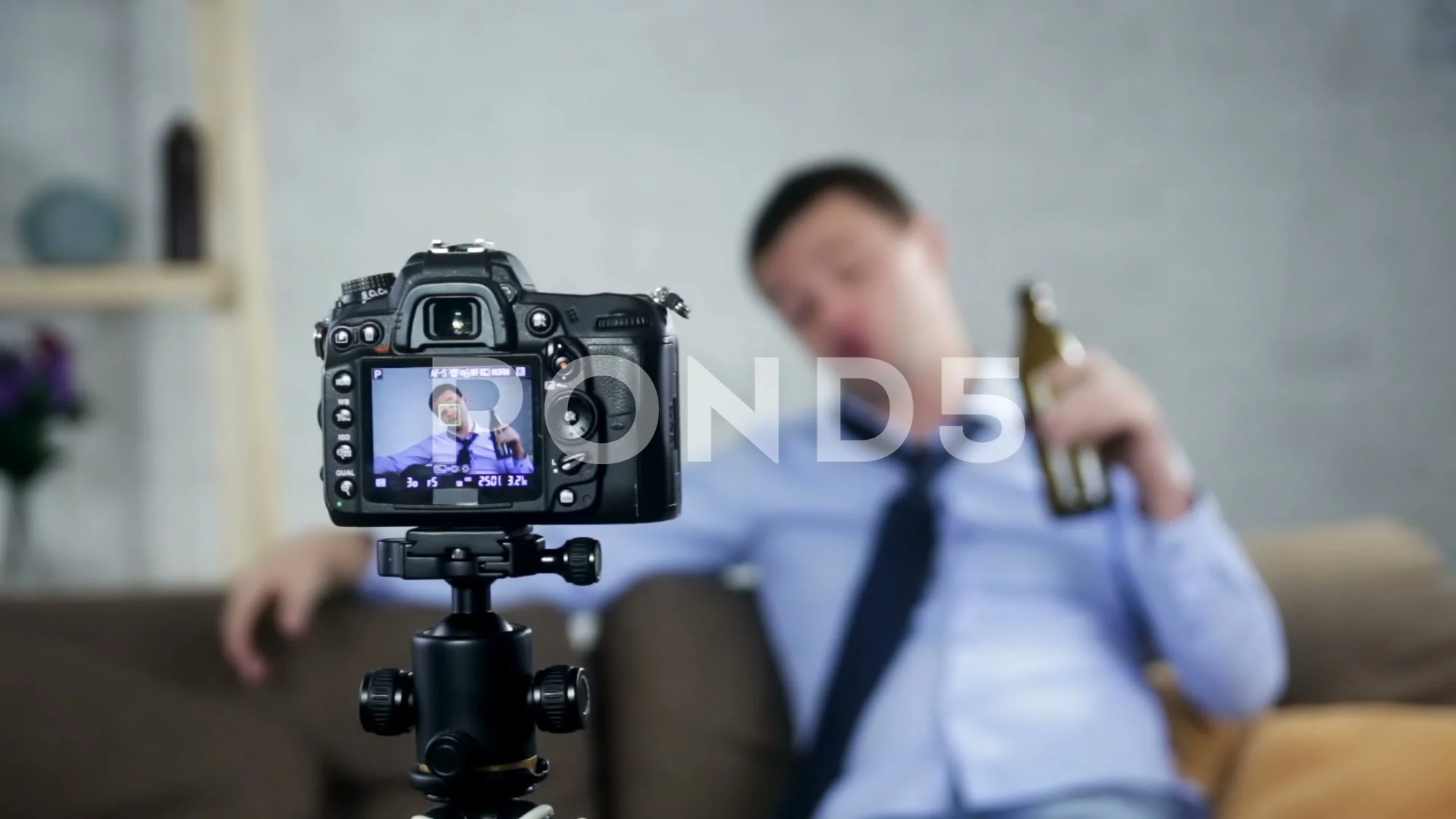Drunk blogger with alcohol at home.Focus on camera. image