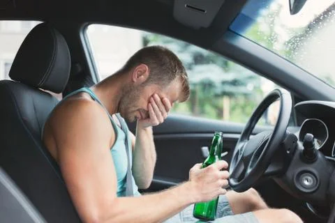 Drunk driver behind the steering wheel of a car Stock Photos