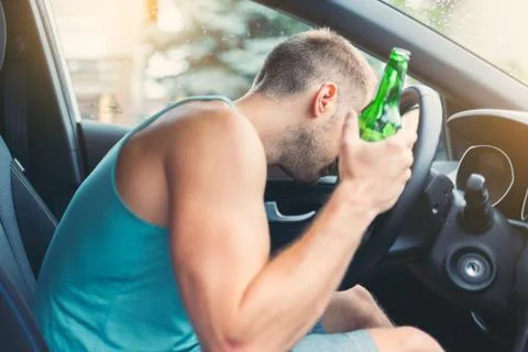 Drunk driver behind the steering wheel of a car Stock Photos
