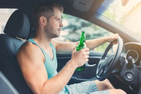Drunk driver behind the steering wheel of a car Stock Photos