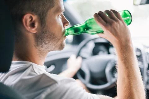 Drunk driver behind the steering wheel of a car Stock Photos