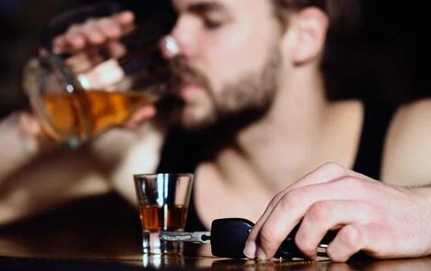 Drunk driver with car key. Alcohol problem. Lonely man drinking before driving Stock Photos