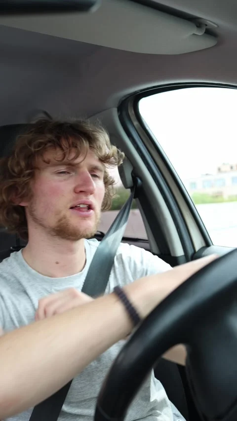 Drunk driver dances to music behind the wheel while moving through city traffic Stock Footage 342922204