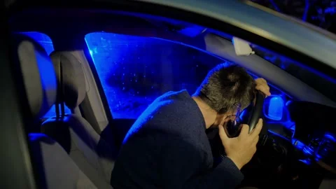 Drunk driver puts head on steering wheel at police lights Stock Footage 155286018