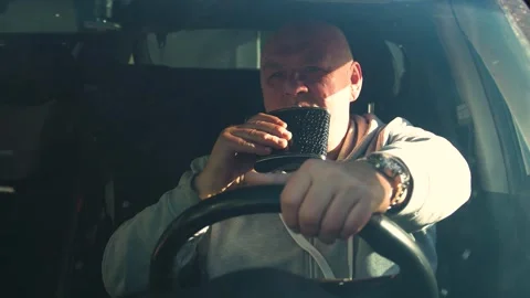 Drunk driving. The driver drinks strong alcohol while driving. Stock Footage 320357041