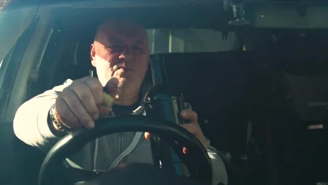 Drunk driving. The driver drinks strong alcohol while driving. Stock Footage 320357224