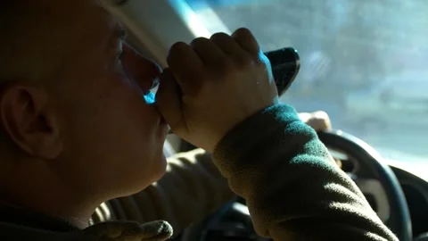 Drunk driving. The driver drinks whiskey while driving. Stock Footage 320356998