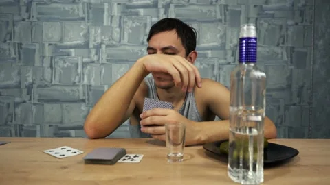 Drunk guy plays cards and drinks vodka Video stock 149114904