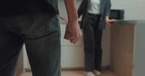 Drunk husband getting close to his wife with fist in the kitchen Stock Footage 258836073