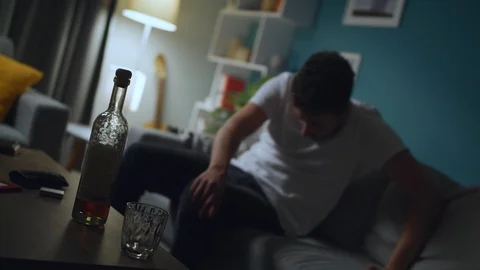 Drunk man drinking alcohol and falls from sofa Stock Footage 112977100